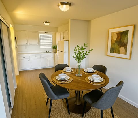 A dining room with a table set for four.