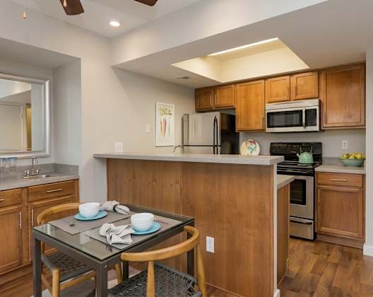 A kitchen with wooden cabinets and a black table.