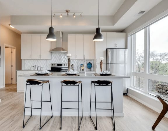 Spacious Kitchen Island with Stylish Pendant Lights at The Whit in Minneapolis, MN