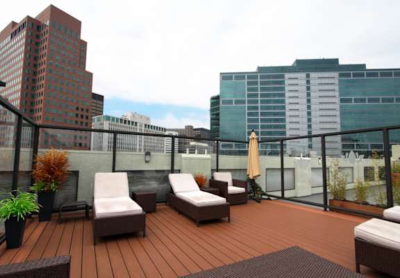 A wooden deck with two lounge chairs and a table at 1022 Tiverton, Los Angeles, CA