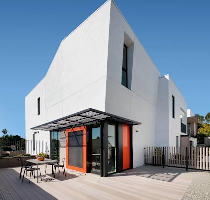 A modern white house with a red door and a black metal fence.at 810 Ashland, Santa Monica, 90405