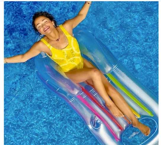 a woman laying in a pool on a water slide