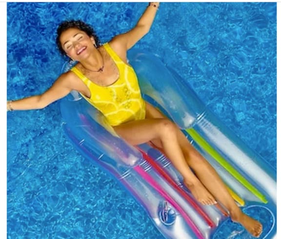 a woman laying in a pool on a water slide