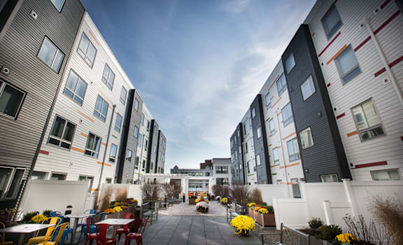 a courtyard between two apartment buildings with tables and chairs