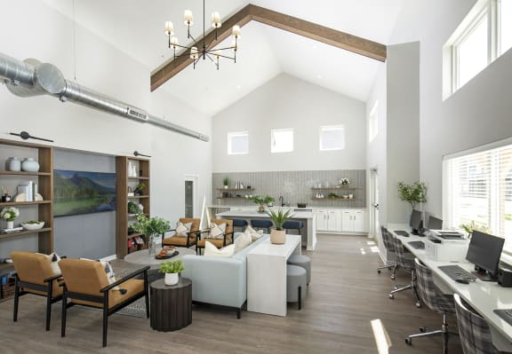 a large living room with couches and chairs and a desk with a computer