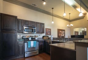 a large kitchen with stainless steel appliances and black cabinets