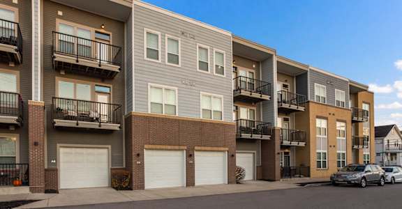 an exterior view of an apartment building with white garage doors