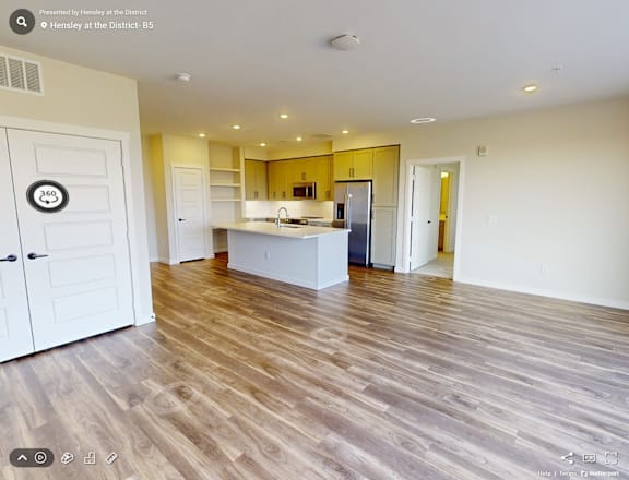 A spacious kitchen with wooden flooring and a white door with number 360 on it.
