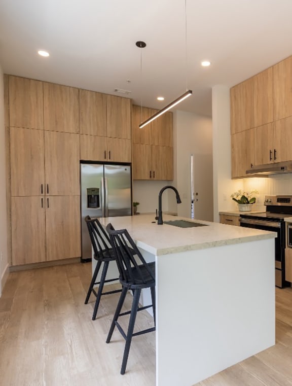 a large kitchen with a white island and wooden cabinets