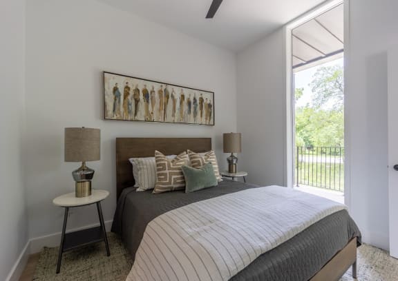 a bedroom with a bed and a door to a balcony