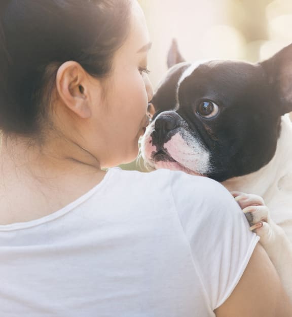 a girl kissing her dog on the face