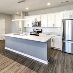 an open kitchen with a large island and stainless steel appliances