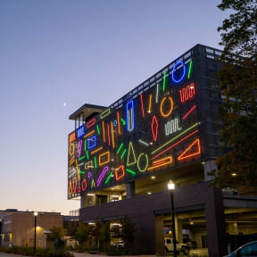 a large neon sign on the side of a building at night