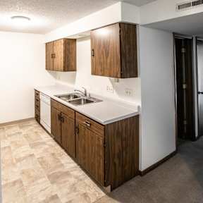 A kitchen with a white fridge and wooden cabinets.