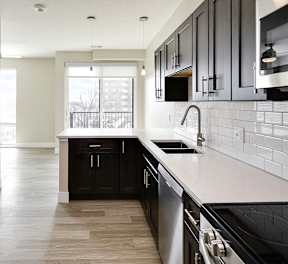 A kitchen with black cabinets and a white countertop.