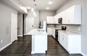 a kitchen with white cabinets and a stainless steel refrigerator
