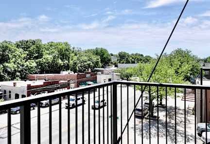 A black metal railing in front of a parking lot and buildings.