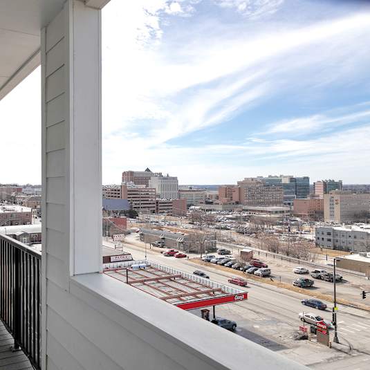 A balcony with a view of a city street and buildings.