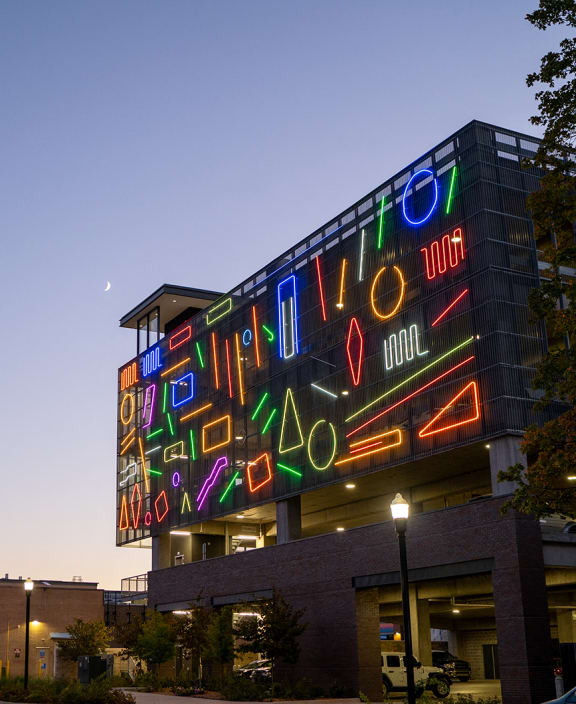 a large neon sign on the side of a building at night