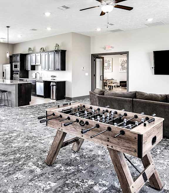 a games room with a foosball table and couches
