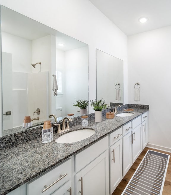 a white bathroom with two sinks and a mirror