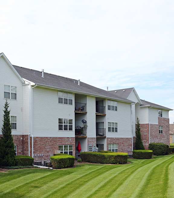A large apartment complex with a green lawn in front.
