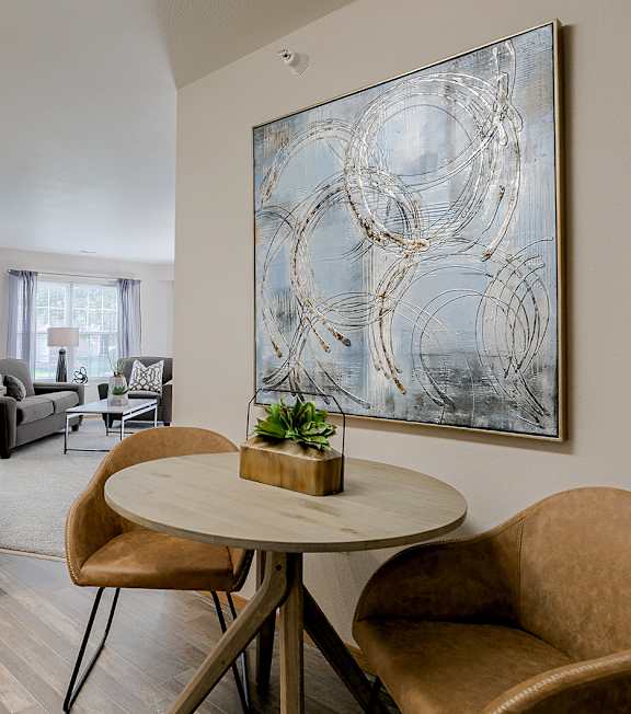 A modern dining area with a round table and two chairs.
