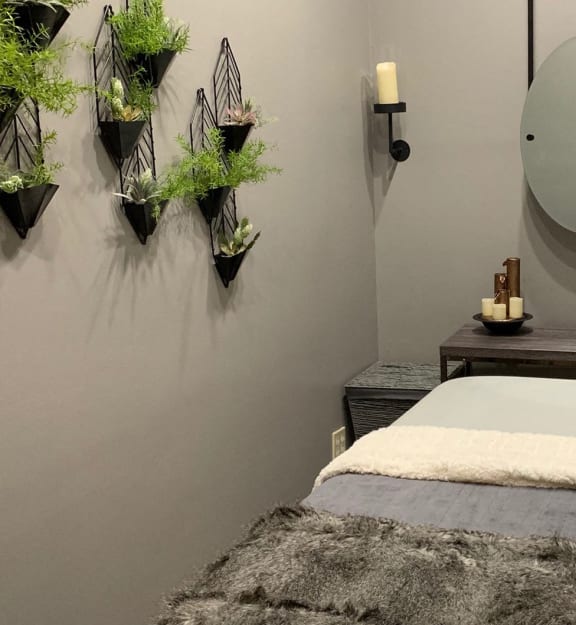 a treatment room with a bed and a mirror