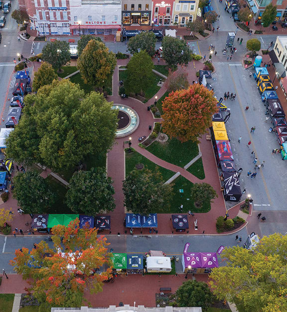 an aerial view of a city street with cars and trees