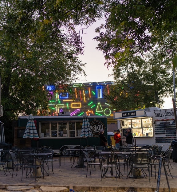 a food truck and tables and chairs in front of a building