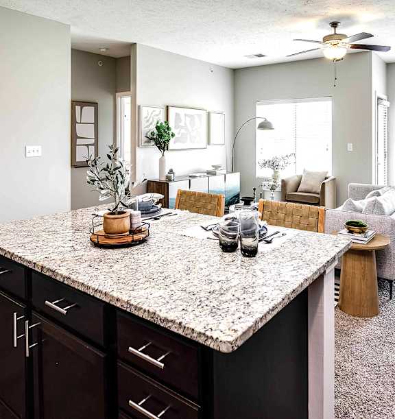an open living room and kitchen with a granite counter top