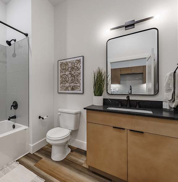 A bathroom with a white toilet, a white shower curtain, and a wooden vanity.