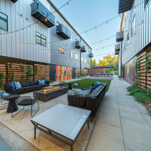 a patio with couches and tables outside of a building