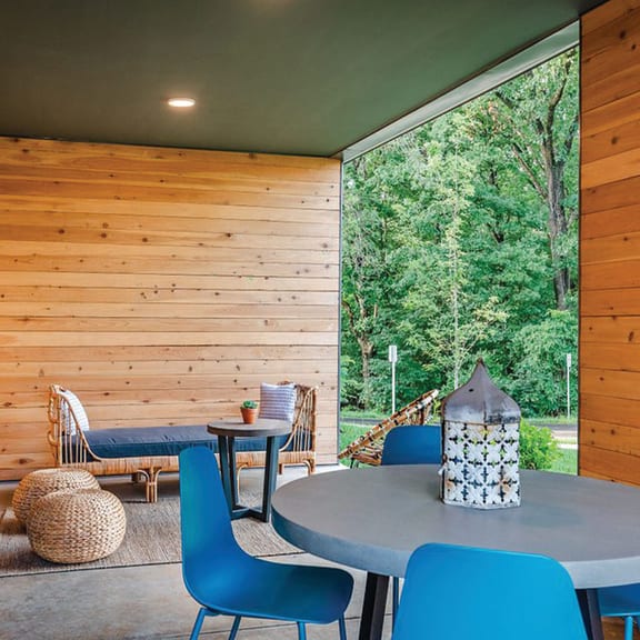 a patio with a table and chairs and a large window