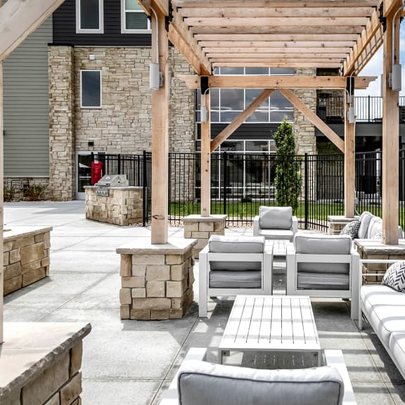 an outdoor patio with couches and a fire pit