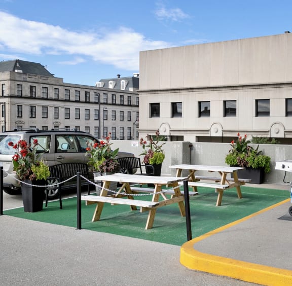 a patio with two picnic tables and two gas grills