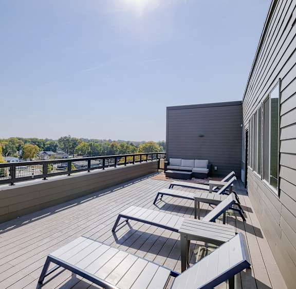 A sunny day on a wooden deck with a view of the trees.