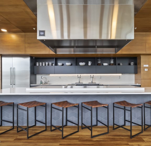 a kitchen with a large center island with four bar stools in front of it