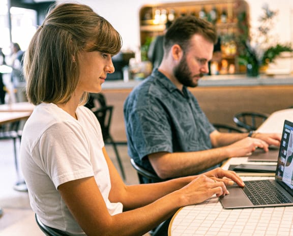people working on laptops at a table