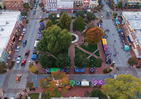 an aerial view of a city street with cars and trees