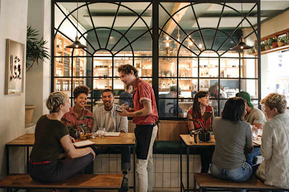 A group of people are sitting at tables in a restaurant.