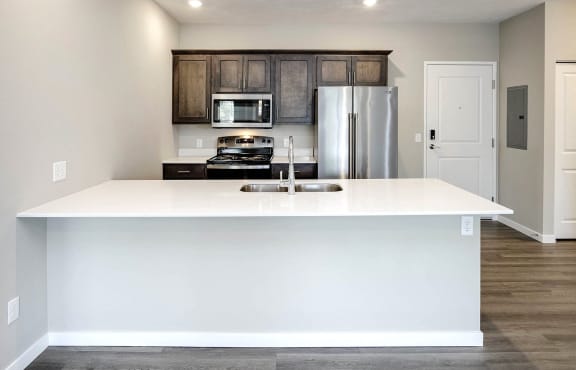 a kitchen with a white counter top and a refrigerator