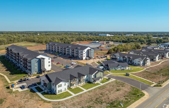 an aerial view of an apartment complex with houses and a road