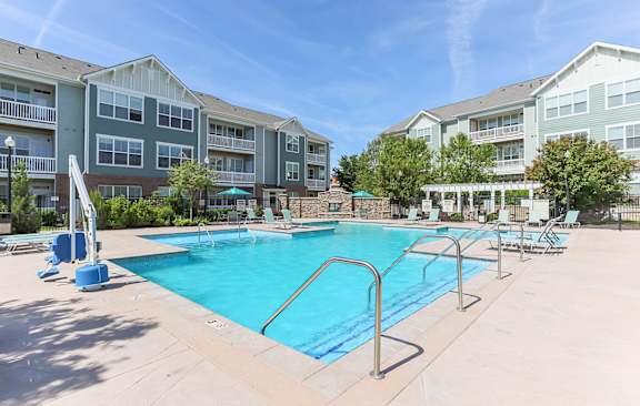 A large swimming pool in front of apartment buildings.
