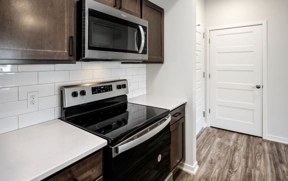 an empty kitchen with a large white counter top