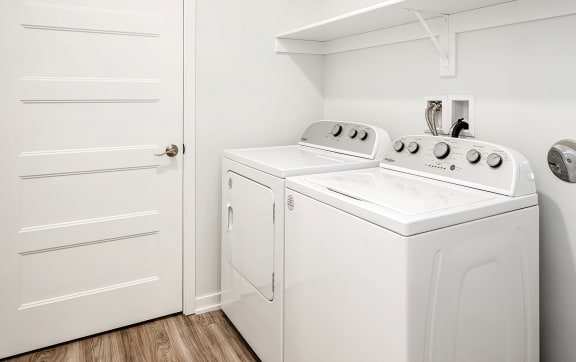 a white washer and dryer in a room with a door