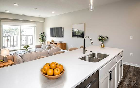 an empty kitchen with a large white counter top