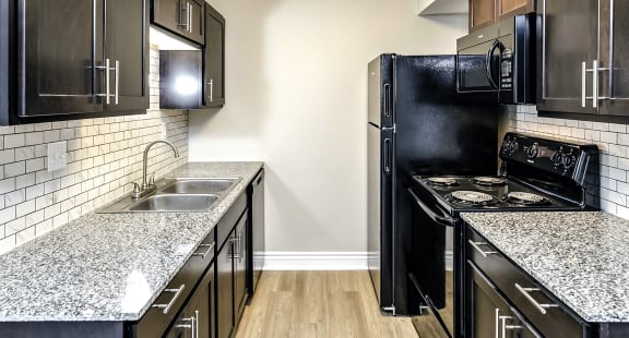 a kitchen with black cabinets and white countertops