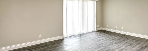 a bedroom with hardwood floors and a large window