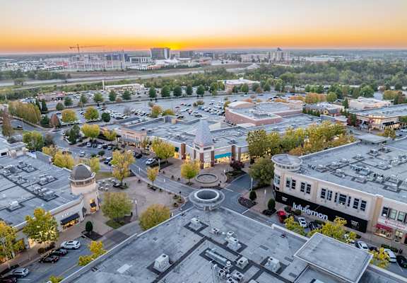 A sunset view of a cityscape with a large open square in the center.